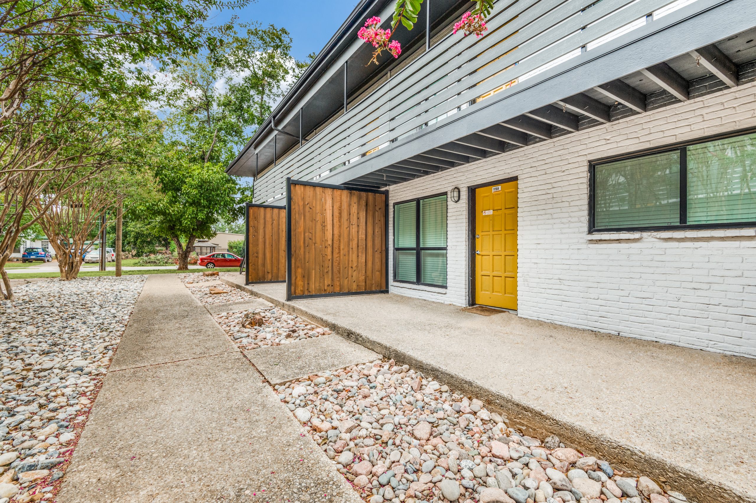 a modern home with a yellow door and gravel walkway at The Palmilla